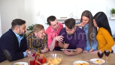 年轻人在平板电脑室内看照片。 和年轻朋友一起玩平板电脑。 多民族